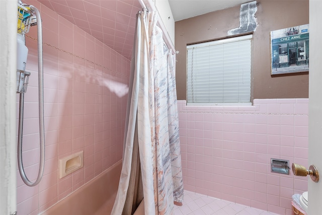 bathroom with tile walls, toilet, and shower / bath combo with shower curtain