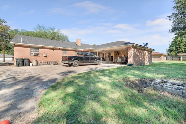 rear view of house with a lawn and cooling unit