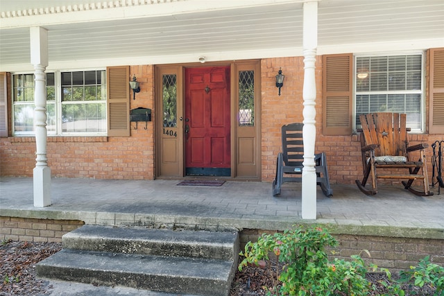 view of exterior entry featuring covered porch