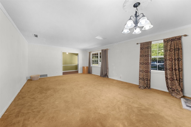 carpeted empty room featuring an inviting chandelier, plenty of natural light, and crown molding