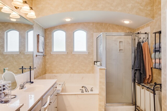 bathroom with shower with separate bathtub, vaulted ceiling, and vanity