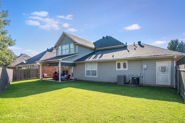 rear view of house with a lawn, cooling unit, and a patio area