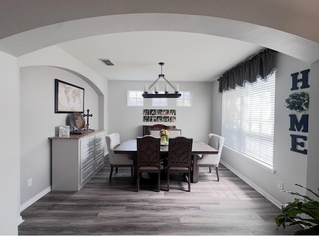 dining room featuring wood finished floors, visible vents, and baseboards