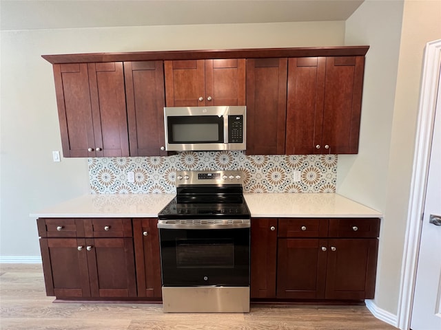 kitchen featuring decorative backsplash, stainless steel appliances, and light hardwood / wood-style flooring