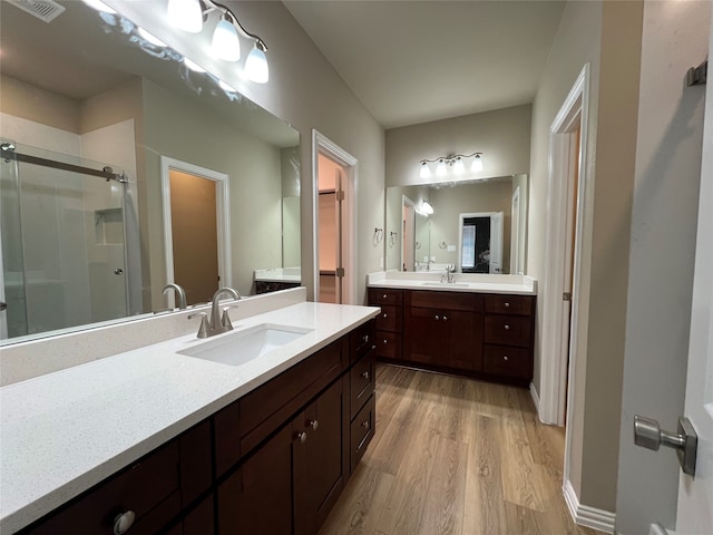 bathroom featuring vanity, an enclosed shower, and hardwood / wood-style flooring