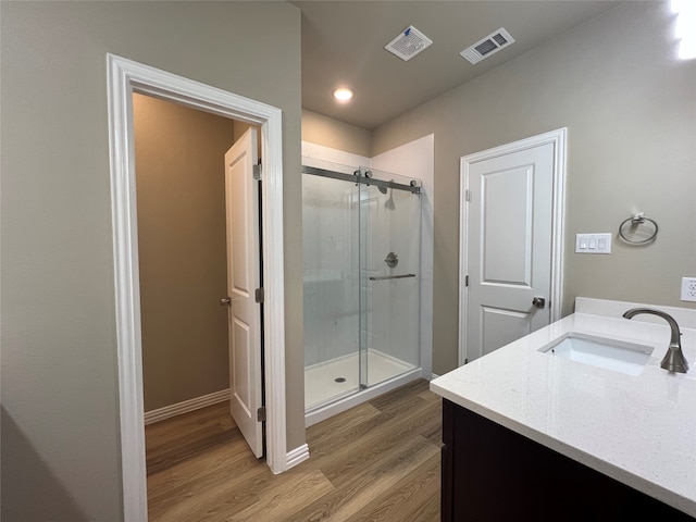 bathroom with vanity, wood-type flooring, and walk in shower