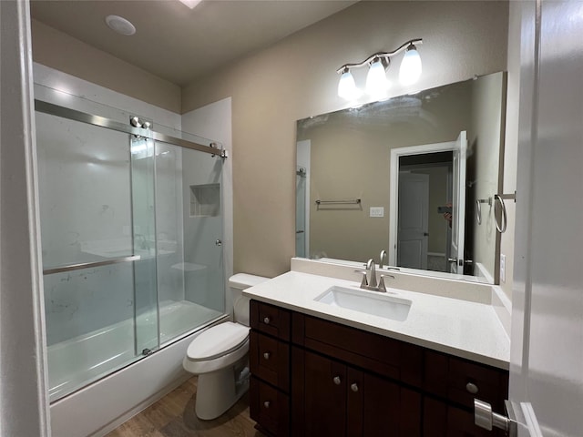 100 Levi Dr, Cleburne, TX 76031 - full bathroom featuring toilet, vanity, enclosed tub / shower combo, and wood finished floors