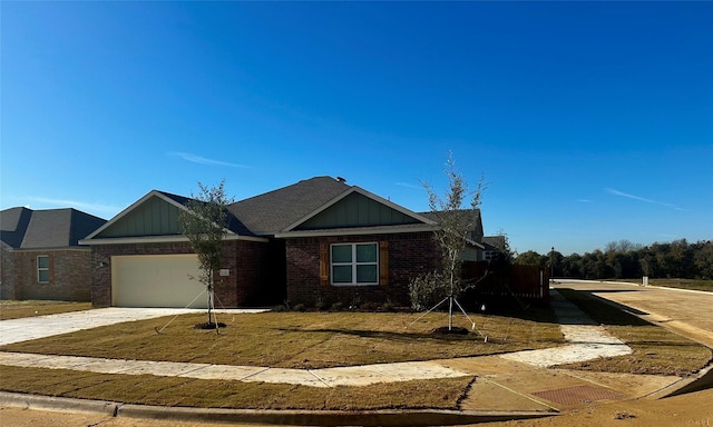 100 Levi Dr, Cleburne, TX 76031 - view of front facade with board and batten siding, brick siding, a garage, and concrete driveway