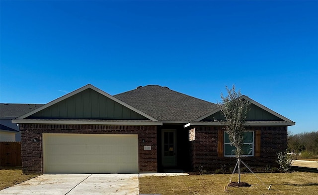 100 Levi Dr, Cleburne, TX 76031 - view of front facade with brick siding, board and batten siding, an attached garage, and driveway