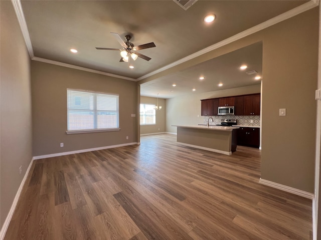 unfurnished living room with ornamental molding, ceiling fan with notable chandelier, dark wood-type flooring, and sink