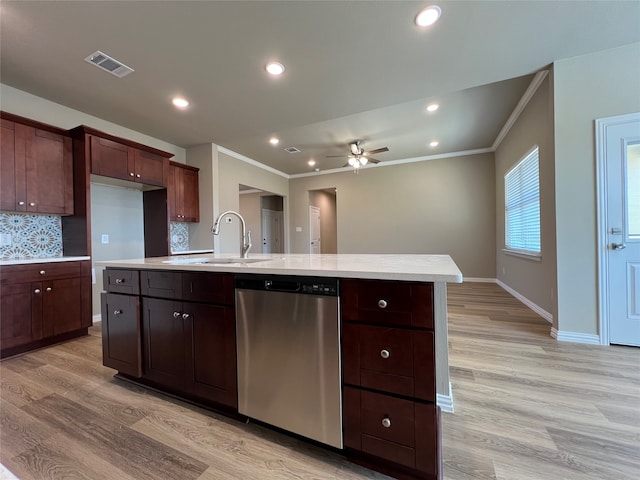 kitchen featuring sink, stainless steel dishwasher, light hardwood / wood-style floors, decorative backsplash, and a center island with sink