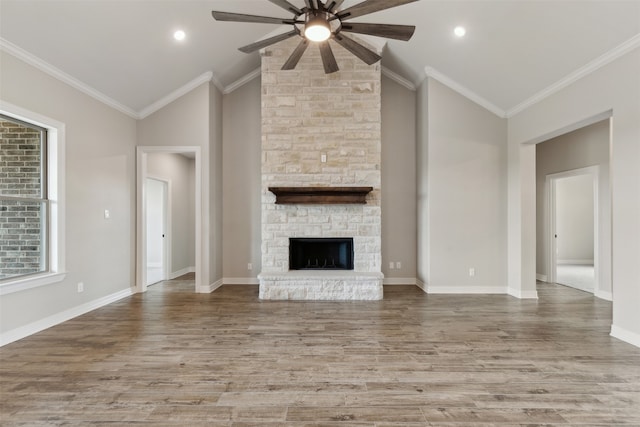 unfurnished living room with lofted ceiling, a fireplace, light hardwood / wood-style flooring, crown molding, and ceiling fan