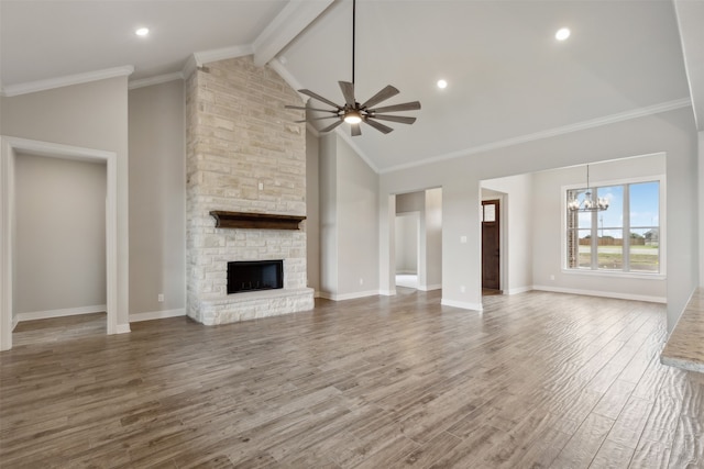 unfurnished living room featuring ceiling fan with notable chandelier, a stone fireplace, beamed ceiling, crown molding, and hardwood / wood-style floors