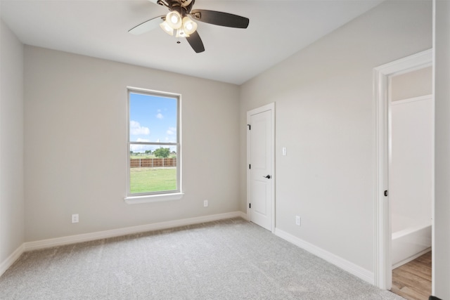 carpeted spare room featuring ceiling fan