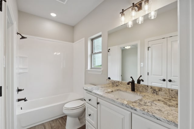 full bathroom featuring hardwood / wood-style floors, vanity, bathtub / shower combination, and toilet