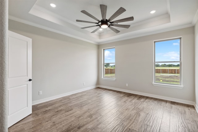 spare room with ceiling fan, ornamental molding, a raised ceiling, and hardwood / wood-style floors