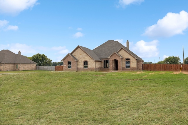 french country style house with a front lawn