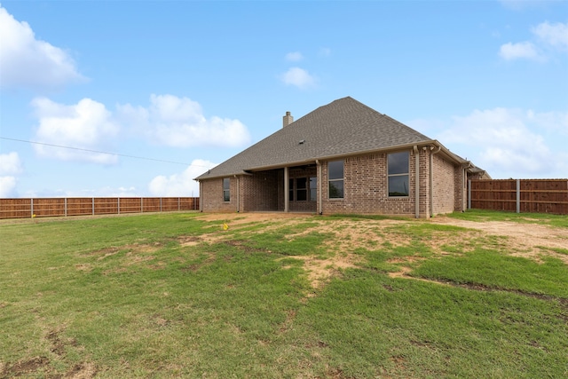 rear view of property featuring a lawn