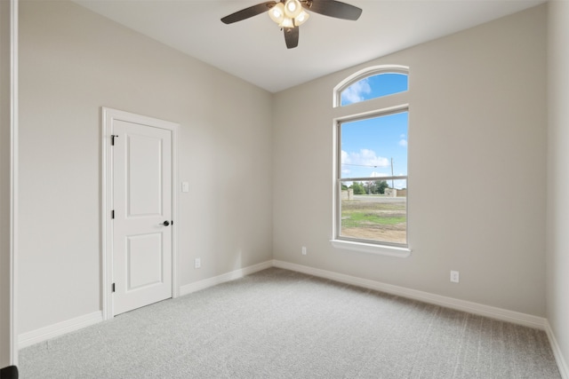 carpeted spare room with ceiling fan