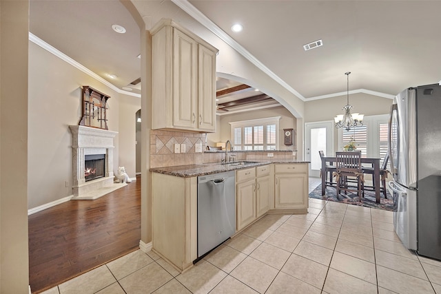 kitchen featuring light hardwood / wood-style floors, ornamental molding, an inviting chandelier, and stainless steel appliances