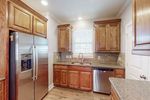 kitchen with decorative backsplash, stainless steel appliances, light wood-type flooring, crown molding, and sink