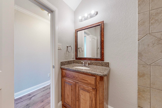 bathroom featuring ornamental molding, vanity, and hardwood / wood-style floors