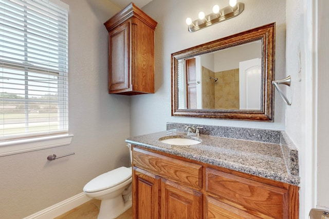 bathroom with a tile shower, tile patterned flooring, vanity, and toilet