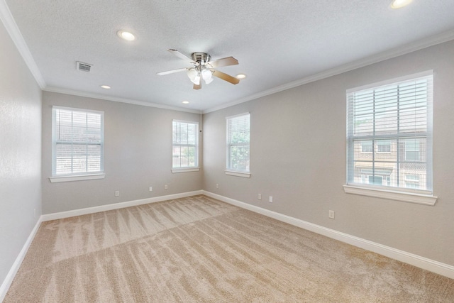 carpeted empty room featuring a textured ceiling, ornamental molding, and ceiling fan