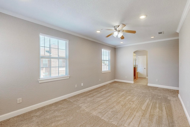 unfurnished room featuring a textured ceiling, crown molding, ceiling fan, and light colored carpet