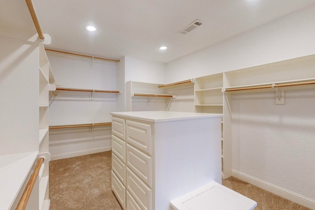 walk in closet featuring light colored carpet