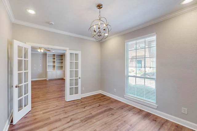 unfurnished room with french doors, ornamental molding, ceiling fan with notable chandelier, and light hardwood / wood-style floors