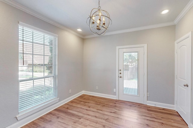 interior space featuring light wood-type flooring, crown molding, a notable chandelier, and a wealth of natural light