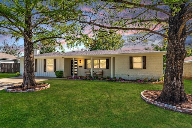 single story home featuring covered porch and a yard