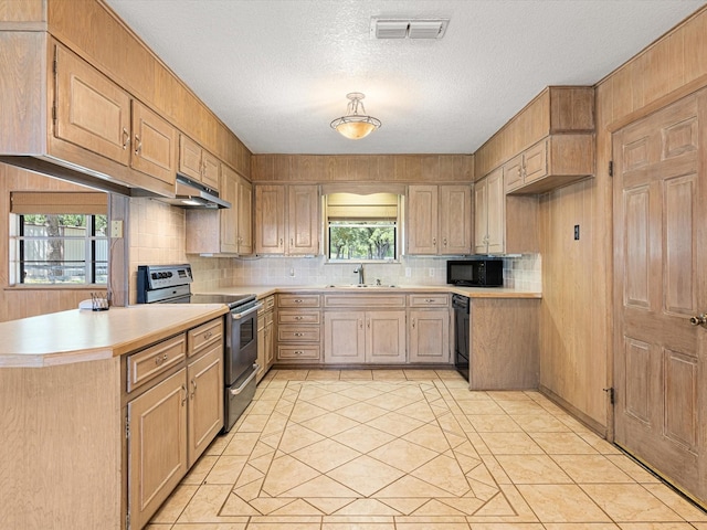 kitchen featuring sink, a textured ceiling, light brown cabinets, kitchen peninsula, and black appliances