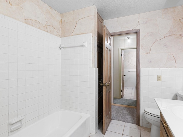 bathroom with a textured ceiling, tile patterned flooring, tile walls, toilet, and vanity