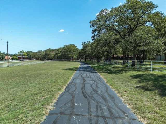 view of property's community with a rural view and a lawn