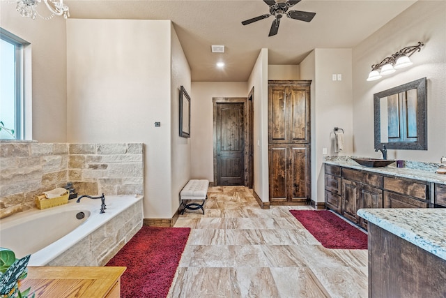 bathroom with vanity, ceiling fan, and a relaxing tiled tub