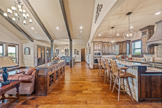 interior space featuring dark stone counters, a large island, dark hardwood / wood-style floors, tasteful backsplash, and stainless steel appliances