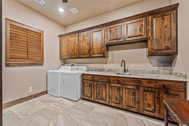 laundry room featuring separate washer and dryer, cabinets, and sink