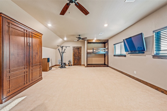 unfurnished living room with ceiling fan, light colored carpet, lofted ceiling, and a healthy amount of sunlight