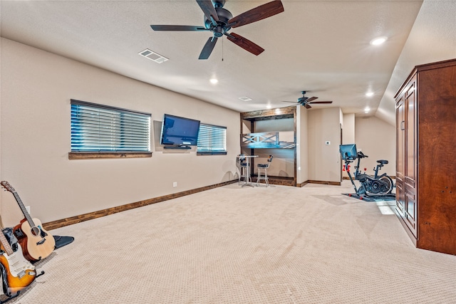 workout area with a textured ceiling, lofted ceiling, light carpet, and ceiling fan