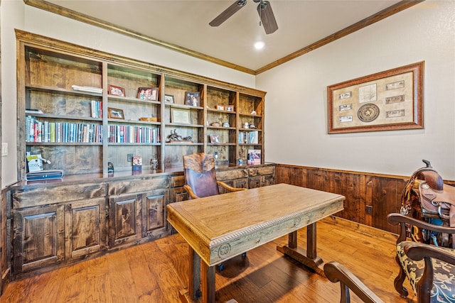 home office featuring ceiling fan, light hardwood / wood-style flooring, wood walls, and ornamental molding