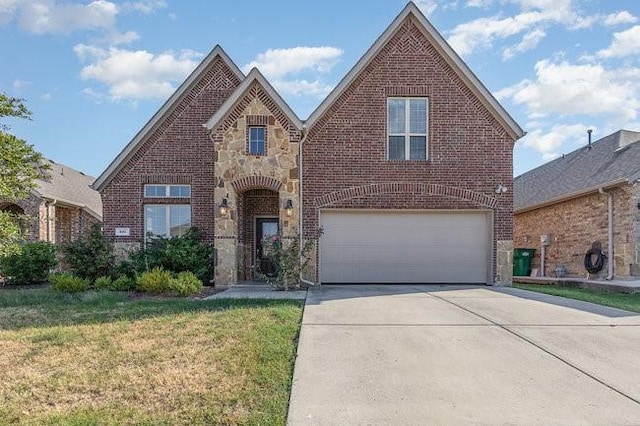 537 England St, Fate, TX 75189 - view of front of property with driveway, a front yard, an attached garage, and brick siding
