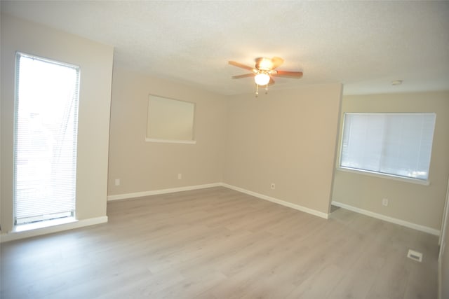 unfurnished room featuring light hardwood / wood-style flooring, ceiling fan, and a textured ceiling