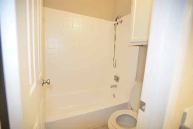 bathroom featuring tiled shower / bath combo and toilet