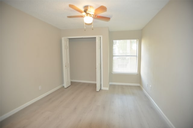 unfurnished bedroom featuring light hardwood / wood-style floors, ceiling fan, and a closet