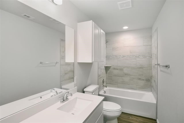 full bathroom with hardwood / wood-style floors, vanity, toilet, and tiled shower / bath combo