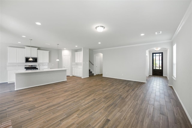 unfurnished living room featuring dark hardwood / wood-style flooring and crown molding