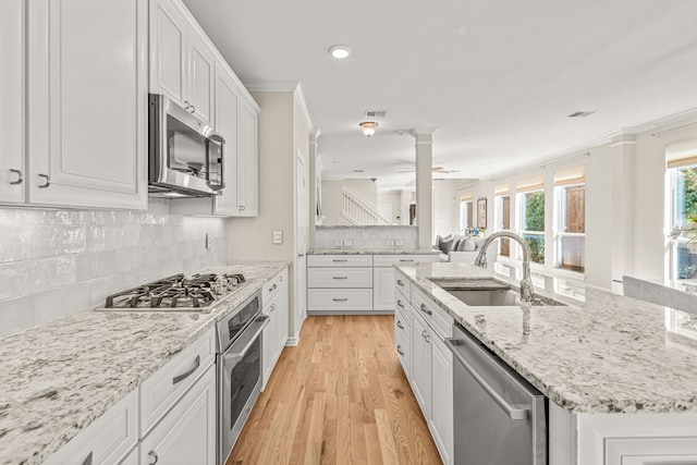 kitchen with ceiling fan, white cabinets, sink, stainless steel appliances, and light wood-type flooring