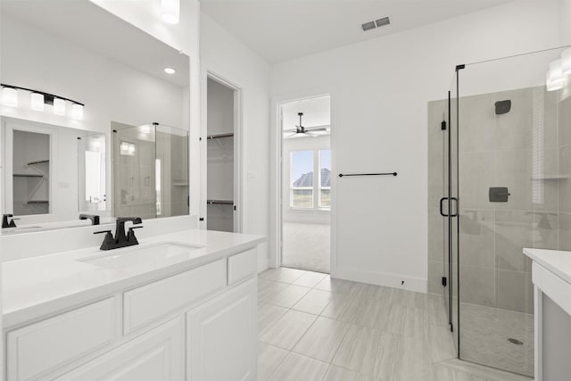 bathroom featuring ceiling fan, vanity, and a shower with door